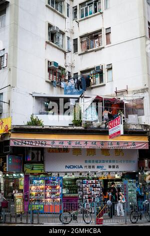 Straßenszene mit Wohnungen über Einzelhandelsgeschäften in Yuen Long, New Territories, Hongkong Stockfoto