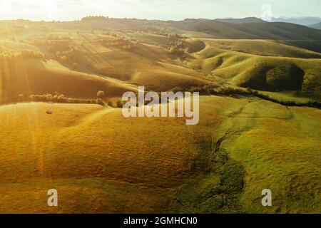 Schöne Zlatibor Berglandschaft bei Sonnenaufgang, Luftaufnahme von Drohne pov. Grasbewachsene Hänge und Täler von oben. Stockfoto