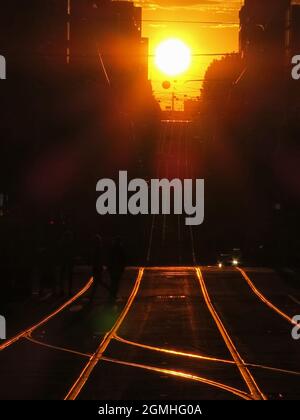 Silhouette bei Sonnenuntergang. Straßenbahnlinien in den Straßen der Stadt Melbourne Australien . Stockfoto