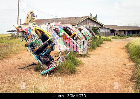 Bemalte Volkswagen Käfer, halb vergraben in einem Winkel auf der Slug Bug Ranch Amarillo Texas auf der Route 66 Stockfoto