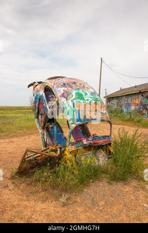 Bemalte Volkswagen Käfer, halb vergraben in einem Winkel auf der Slug Bug Ranch Amarillo Texas auf der Route 66 Stockfoto