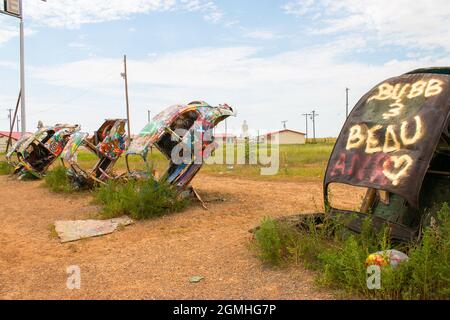 Bemalte Volkswagen Käfer, halb vergraben in einem Winkel auf der Slug Bug Ranch Amarillo Texas auf der Route 66 Stockfoto