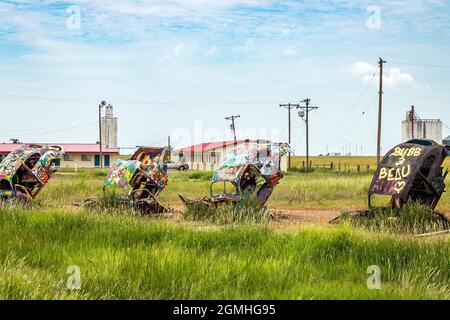 Bemalte Volkswagen Käfer, halb vergraben in einem Winkel auf der Slug Bug Ranch Amarillo Texas auf der Route 66 Stockfoto