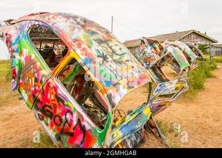 Bemalte Volkswagen Käfer, halb vergraben in einem Winkel auf der Slug Bug Ranch Amarillo Texas auf der Route 66 Stockfoto