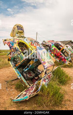 Bemalte Volkswagen Käfer, halb vergraben in einem Winkel auf der Slug Bug Ranch Amarillo Texas auf der Route 66 Stockfoto