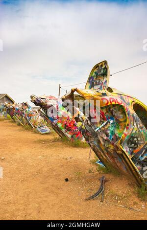 Bemalte Volkswagen Käfer, halb vergraben in einem Winkel auf der Slug Bug Ranch Amarillo Texas auf der Route 66 Stockfoto