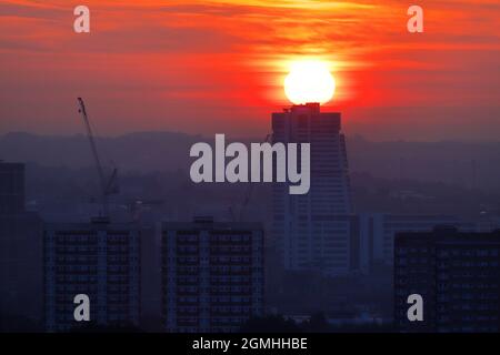 Die Sonne geht direkt hinter dem Bridgewater Place Gebäude in Leeds auf, auch bekannt als Dalek Stockfoto