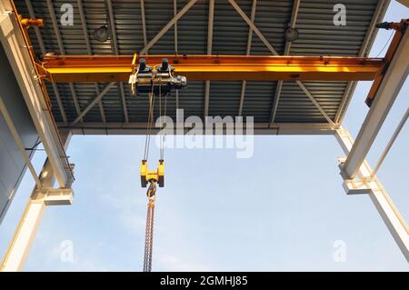Unter dem Vordach des Materiallagers installierter Werkshirdkran. Stockfoto