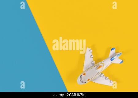 Kleines Modellflugzeug in einer Ecke mit gelbem und blauem Hintergrund Stockfoto