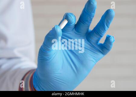 Arzt hält Latexhandschuhe mit der medizinischen Pille Stockfoto