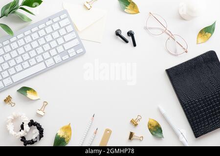 Flacher Schreibtisch für Frauen. Weiblicher Arbeitsplatz mit Tastatur, Notebook, Brille, Zubehör auf weißem Hintergrund. Draufsicht femininer Arbeitsplatz Stockfoto