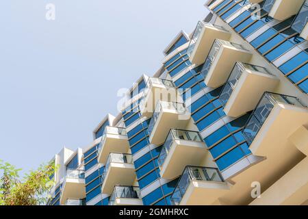 Ein Fragment des Hotelgebäudes, Fenster und Balkone gegen den Himmel. Design und Architektur, Details von Gebäuden. Stockfoto