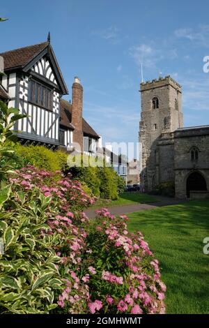 Der normannische Turm der Holy Trinity Parish Church, rechts, und die alte Guildhall, links, in Much Wenlock, Shropshire, England, VEREINIGTES KÖNIGREICH Stockfoto