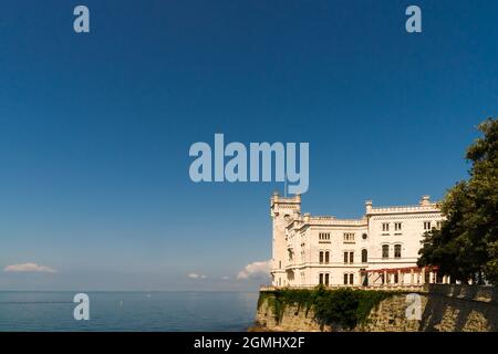 Morgenansicht des Schlosses Miramare in der Nähe von Triest gegen den blauen Himmel und das blaue Meer Stockfoto