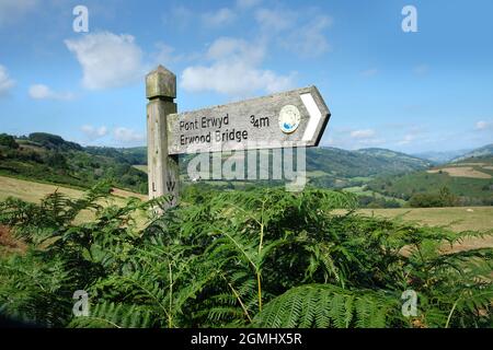 Zweisprachige Fingerpost aus Holz nach Pont Erwyd, Erwood Bridge, auf dem Wye Valley Walk, auf Epynt, Powys, Wales. Stockfoto