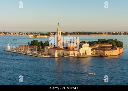 Die Kirche und das Kloster San Giorgio Maggiore in der Lagune von Venedig aus der Luft gesehen, bei Sonnenuntergang Stockfoto