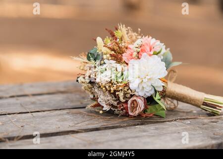 Schön zubereiteter Strauß getrockneter Blumen für die Braut, auf dem Holztisch. Hochwertige Fotos Stockfoto