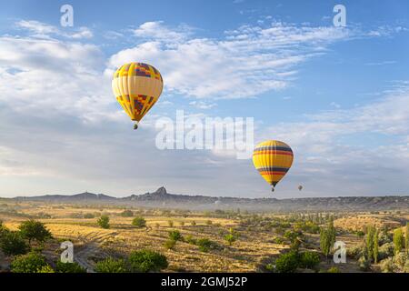 Zwei bunte Heißluftballons treiben über ein malerisches Tal von Kappadokien in der Türkei Stockfoto