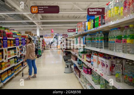 Taplow, Großbritannien. September 2021. Ein Shopper in der Energy Drinks und Wasserinsel. Sainsbury's Supermarket hatte heute ein gutes Angebot an Lebensmitteln in ihrem Laden. Einige Linien sind immer noch von Problemen in der Lieferkette betroffen, darunter Mineralwasser und kohlensäurehaltige Getränke wie Coca-Cola aufgrund eines Mangels an Kohlendioxid und Aluminium. Quelle: Maureen McLean/Alamy Live News Stockfoto