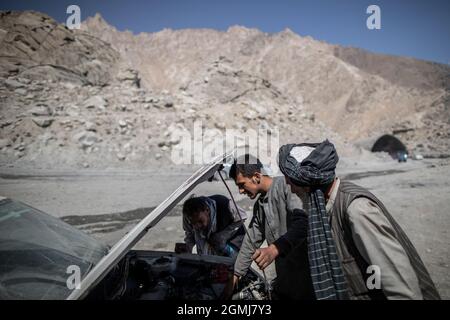 Salang Pass, Afghanistan. September 2021. Afghanische Männer versuchen, ein Auto zu reparieren, nachdem es beim Überqueren des Hindukusches auf dem Salang Pass, dem primären Bergpass, der Nordafghanistan mit der Provinz Parwan verbindet, mit Weiterverbindungen in die Provinz Kabul zusammenbrach. Quelle: Oliver Weiken/dpa/Alamy Live News Stockfoto