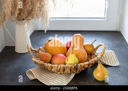 Weidenkorb mit Kürbissen, Äpfeln, Birnen Stockfoto