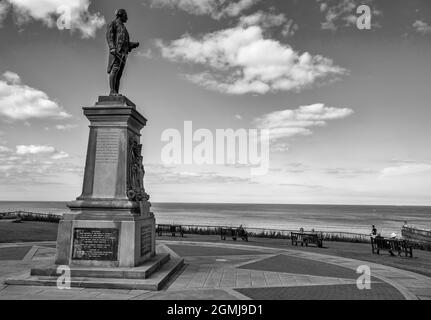 Gedenkstatue für den Entdecker der Royal Navy aus dem 16. Jahrhundert, Captain James Cook, mit Blick auf den Hafen von Whitby, der Amerika, Australien und Neuseeland erkundete Stockfoto