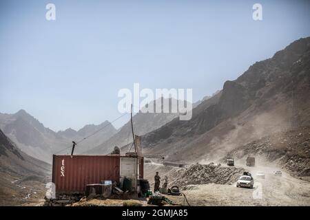 Salang Pass, Afghanistan. September 2021. Ein afghanischer Händler sieht zu, wie Autos und Lastwagen den Hindukusch auf dem Salang Pass überqueren, dem primären Bergpass, der Nordafghanistan mit der Provinz Parwan verbindet, mit Weiterverbindungen in die Provinz Kabul. Quelle: Oliver Weiken/dpa/Alamy Live News Stockfoto