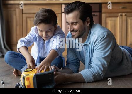 Nahaufnahme glücklicher Vater mit kleinen Sohn Befestigung Spielzeugauto Stockfoto