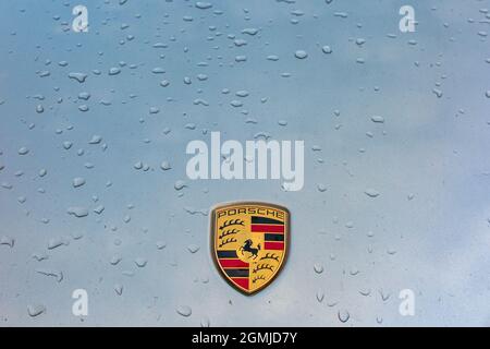 Porsche-Plakette auf der Motorhaube von 911 mit Tröpfchen Regenwasser Stockfoto