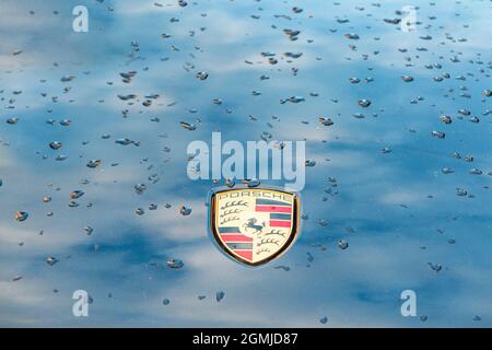 Porsche-Plakette auf der Motorhaube von 911 mit Tröpfchen Regenwasser Stockfoto