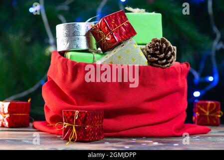 weihnachtsmann Tasche mit Geschenken auf weihnachtskiefer Hintergrund Stockfoto