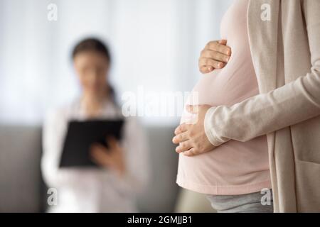 Nahaufnahme einer Frau, die ein Baby erwartet und einen Termin mit einem Arzt hat Stockfoto