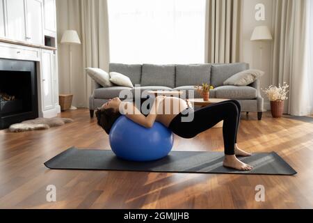 Junge erwartete Mutter liegen auf Fitball tun Gymnastik Stockfoto