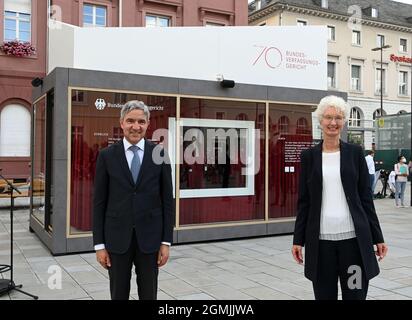 19. September 2021, Baden-Württemberg, Karlsruhe: Stephan Harbarth, Präsident des Bundesverfassungsgerichts, und Doris König, Vizepräsidentin des Bundesverfassungsgerichts, stehen auf dem Marktplatz vor einem Glasbehälter (Cube), in dem unter anderem die roten Roben der Verfassungsrichter und Videostatements von Mitarbeitern zu sehen sind. Damit erinnert das Gericht an seine Gründung vor 70 Jahren. Das Bundesverfassungsgericht hat seine Arbeit am 7. September 1951 aufgenommen, die erste Entscheidung wurde zwei Tage später erlassen. Das Gericht wurde am 28. September in offiziell eröffnet Stockfoto