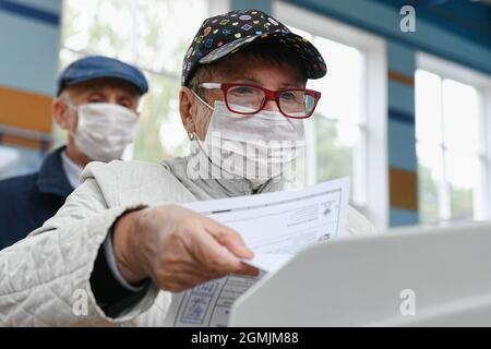 Moskau, Russland. September 2021. Eine Frau wirft ihre Stimme während der Wahlen zur russischen Staatsduma in Moskau, Russland, am 19. September 2021 in die Wahlurne. Russland führt vom 17. Bis 19. September Wahlen für die Abgeordneten der Staatsduma oder des Unterhauses des parlaments durch. Quelle: Evgeny Sinitsyn/Xinhua/Alamy Live News Stockfoto