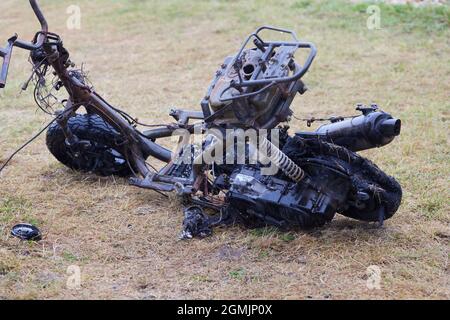 Ausgebranntes Motorrad auf einem Rasen gesehen. Stockfoto