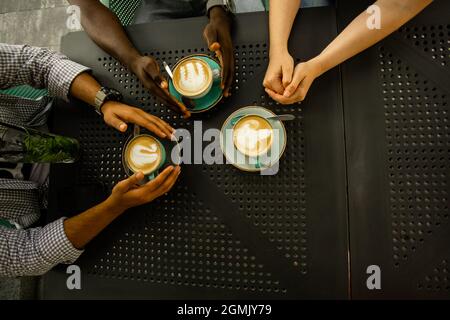 Multiethnische Menschen mit Kaffeetassen, Draufsicht Stockfoto