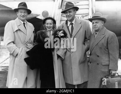 JOHN WAYNE und Präsident der Republik Bilder HERBERT J. YATES (rechts) mit VERA RALSTON (die Yates im März 1952 heiratete) Und FORREST TUCKER neben dem Pan am Airplane nach ihrer Ankunft in London am Samstag, dem 24. Februar 1951, um am folgenden Montag neue Räumlichkeiten für Republic Picters auf dem Soho Square zu eröffnen und an der Premiere ihres neuesten Films RIO GRANDE am Freitag, dem 2. März, im Carlton Theatre teilzunehmen Werbung für Pan American World Airways Stockfoto