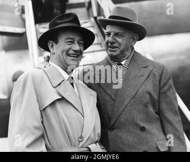 JOHN WAYNE und President of Republic Pictures HERBERT J. YATES neben dem Pan am Airplane nach ihrer Ankunft in London am Samstag, dem 24. Februar 1951, um am folgenden Montag neue Räumlichkeiten für Republic Picturs auf dem Soho Square zu eröffnen und an der Premiere ihres neuesten Films RIO GRANDE On teilzunehmen Freitag, 2. März, im Carlton Theatre Publicity für Pan American World Airways Stockfoto