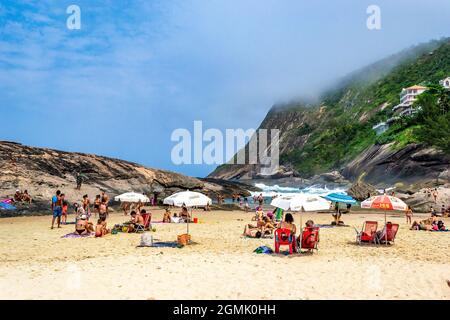 Touristen genießen den Strand von Itacoatiara in Niteroi, Rio de Janeiro, Brasilien. Mit einer wunderschönen Landschaft ist dieser Strand berühmt für das ideale CO Stockfoto