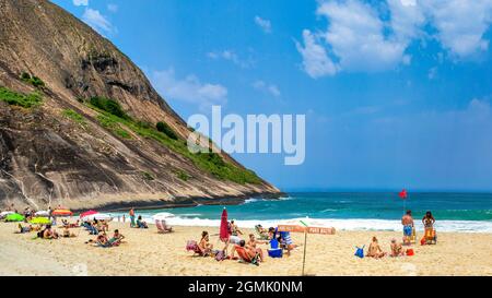 Touristen genießen den Strand von Itacoatiara in Niteroi, Rio de Janeiro, Brasilien. Mit einer wunderschönen Landschaft ist dieser Strand berühmt für das ideale CO Stockfoto