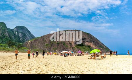 Touristen genießen den Strand von Itacoatiara in Niteroi, Rio de Janeiro, Brasilien. Mit einer wunderschönen Landschaft ist dieser Strand berühmt für das ideale CO Stockfoto