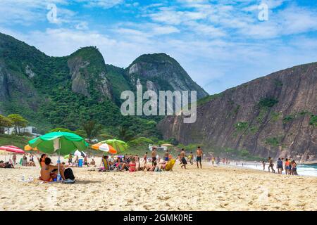 Touristen genießen den Strand von Itacoatiara in Niteroi, Rio de Janeiro, Brasilien. Mit einer wunderschönen Landschaft ist dieser Strand berühmt für das ideale CO Stockfoto