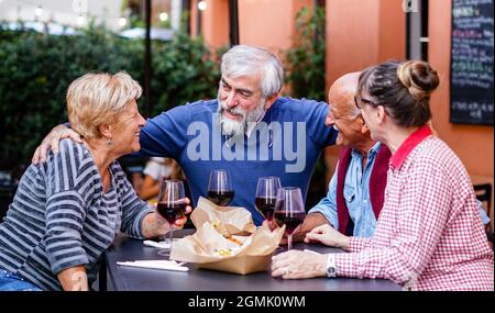 Eine Gruppe alter Leute, die draußen essen und trinken - Senioren, die Spaß haben Stockfoto