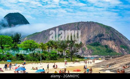 Touristen genießen den Strand von Itacoatiara in Niteroi, Rio de Janeiro, Brasilien. Mit einer wunderschönen Landschaft ist dieser Strand berühmt für das ideale CO Stockfoto