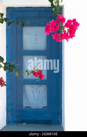 Traditionelles griechisches Haus mit blau gestrichenen Fensterrahmen an einer weißen Wand Stockfoto
