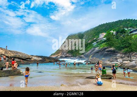 Touristen genießen den Strand von Itacoatiara in Niteroi, Rio de Janeiro, Brasilien. Mit einer wunderschönen Landschaft ist dieser Strand berühmt für das ideale CO Stockfoto