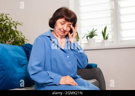 Die ältere Frau leidet unter Kopfschmerzen Stockfoto
