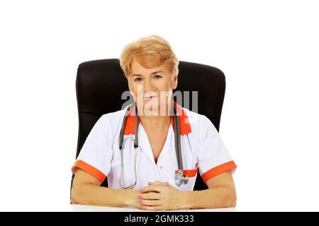 Eine freundliche polnische ältere Krankenschwester in Uniform, die in einem Schrank sitzt Stockfoto