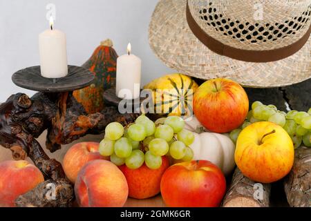 Ein herbstliches Stillleben mit Früchten, Hut und Wein Stockfoto